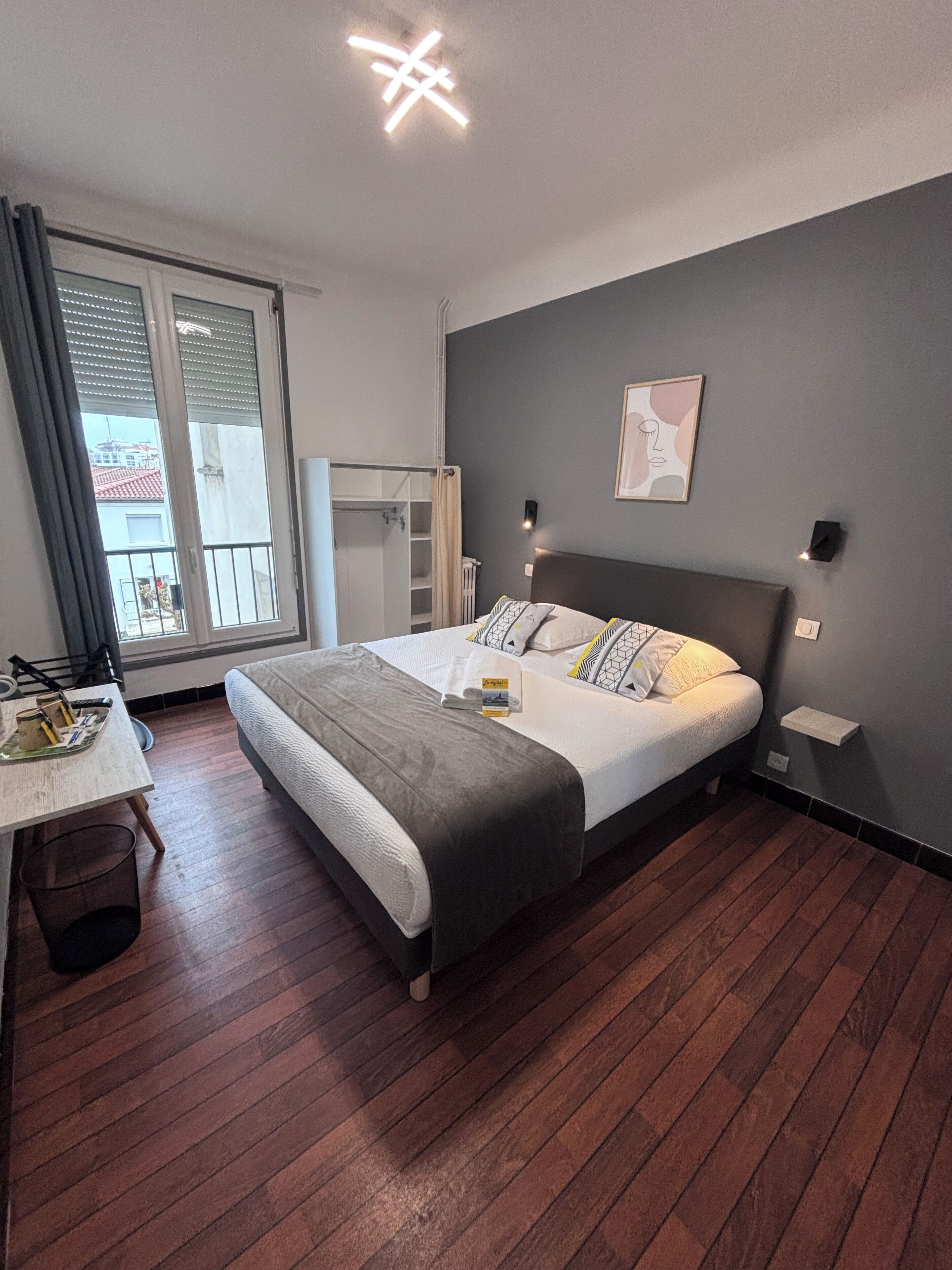 Un dormitorio con cama, escritorio, silla, armario y ventana.