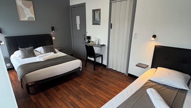 A hotel room with two beds, a desk, and a wardrobe. - Le Crystal Hôtel (Royan)