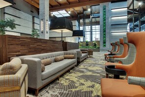 A modern lounge area with sofas, armchairs, and a patterned carpet. - Mount Vernon Hotel and Event Center (Mount Vernon)