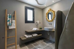 Un baño moderno con banco integrado, ventana, tocador con lavabo y espejo grande.