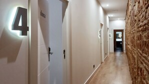 A hallway with doors numbered 4 and 6, light fixtures, and a textured wall.