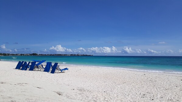 Accommodatie ligt op het strand, wit zand, ligstoelen, parasols