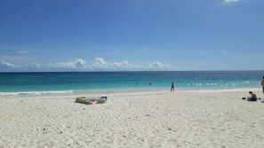 On the beach, white sand, sun-loungers, beach umbrellas