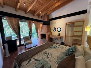 Une chambre à coucher comprenant un lit, une chaise, une cheminée, un bureau et une armoire.