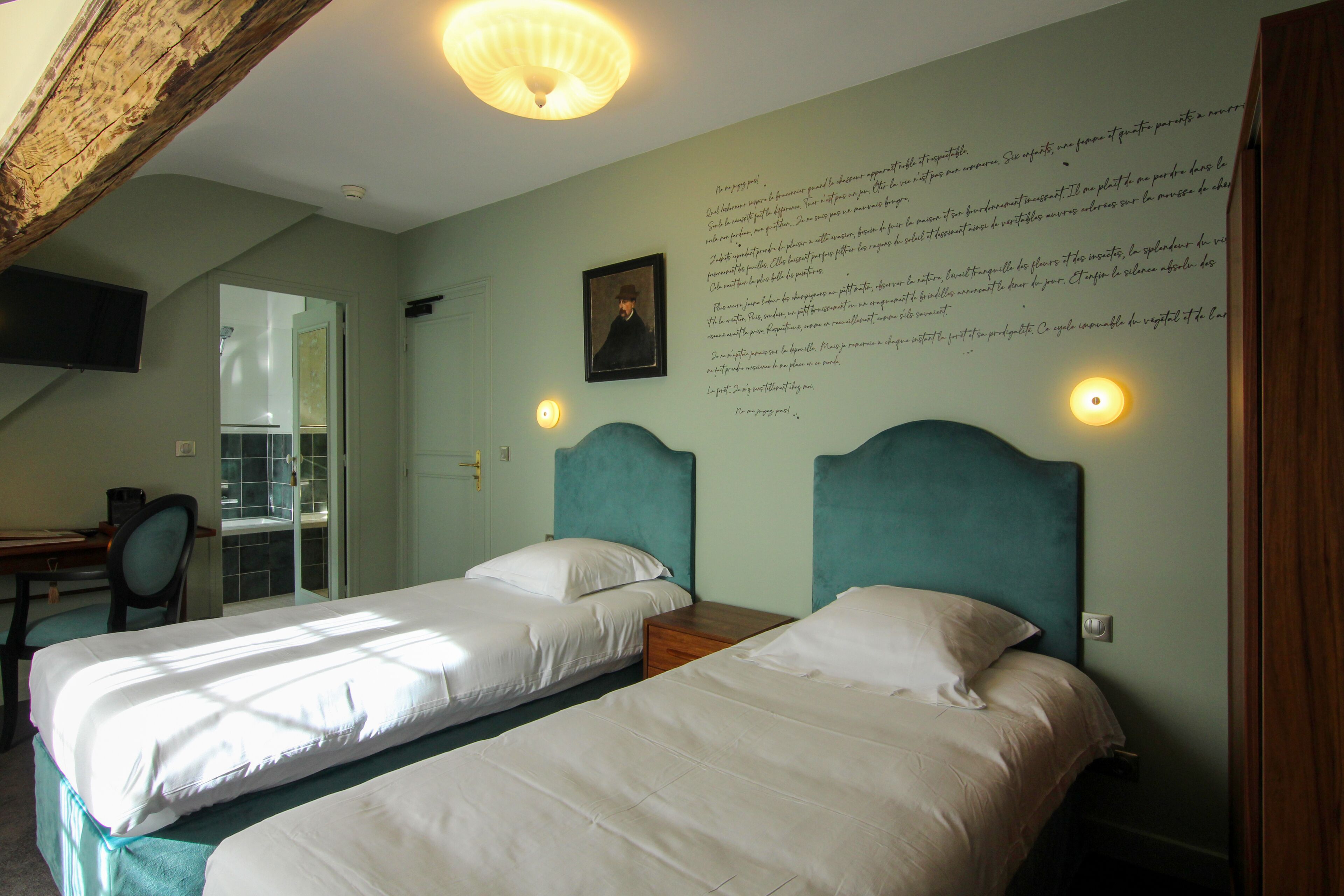 A bedroom with two beds, a desk, and a chair.