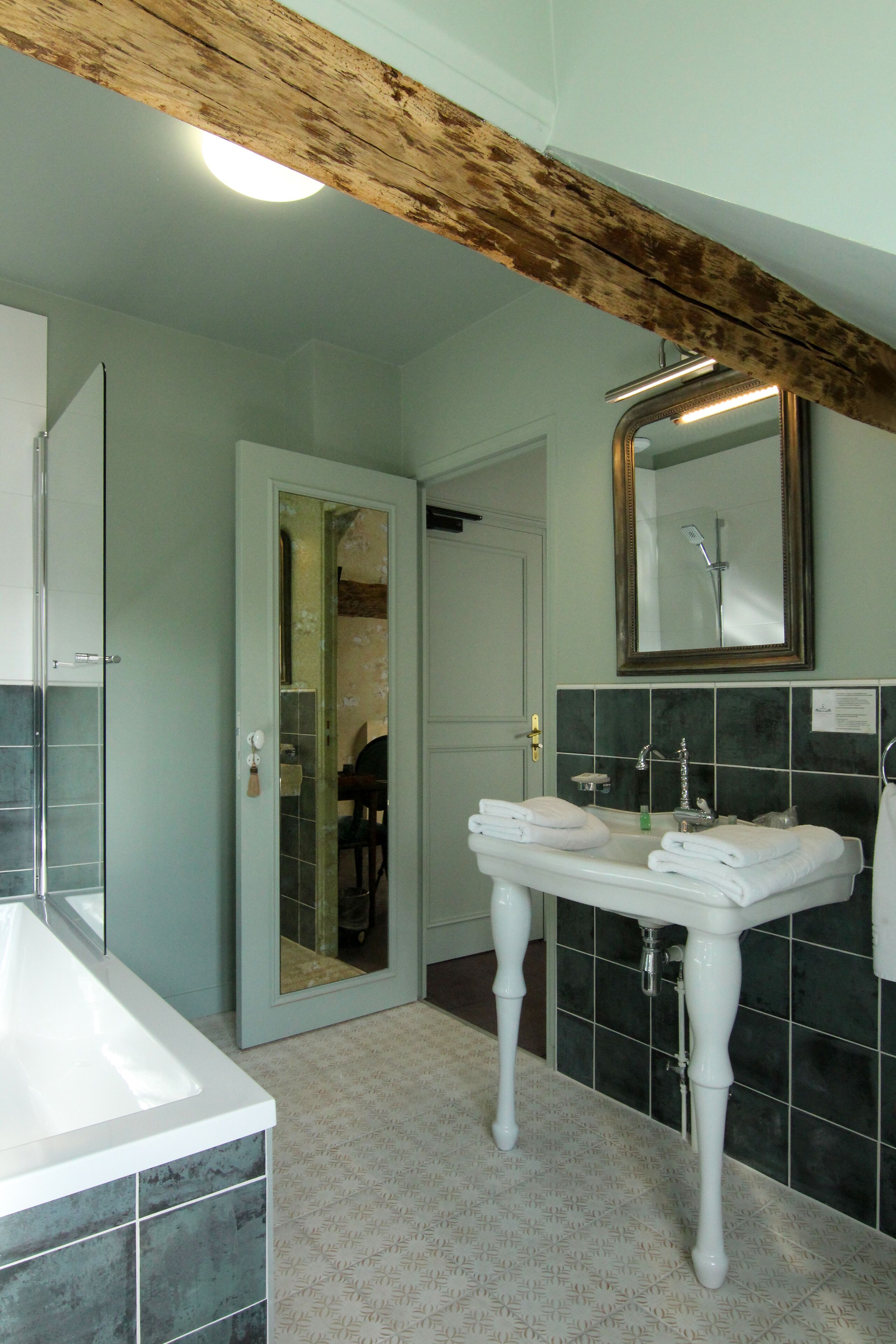 A bathroom with a white sink, a mirror, and a tiled floor.