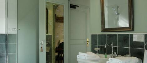 A bathroom with a white sink, a mirror, and a tiled floor.