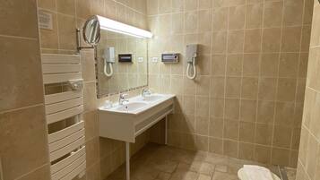 A bathroom with two sinks, a mirror, a towel rack, and a toilet.