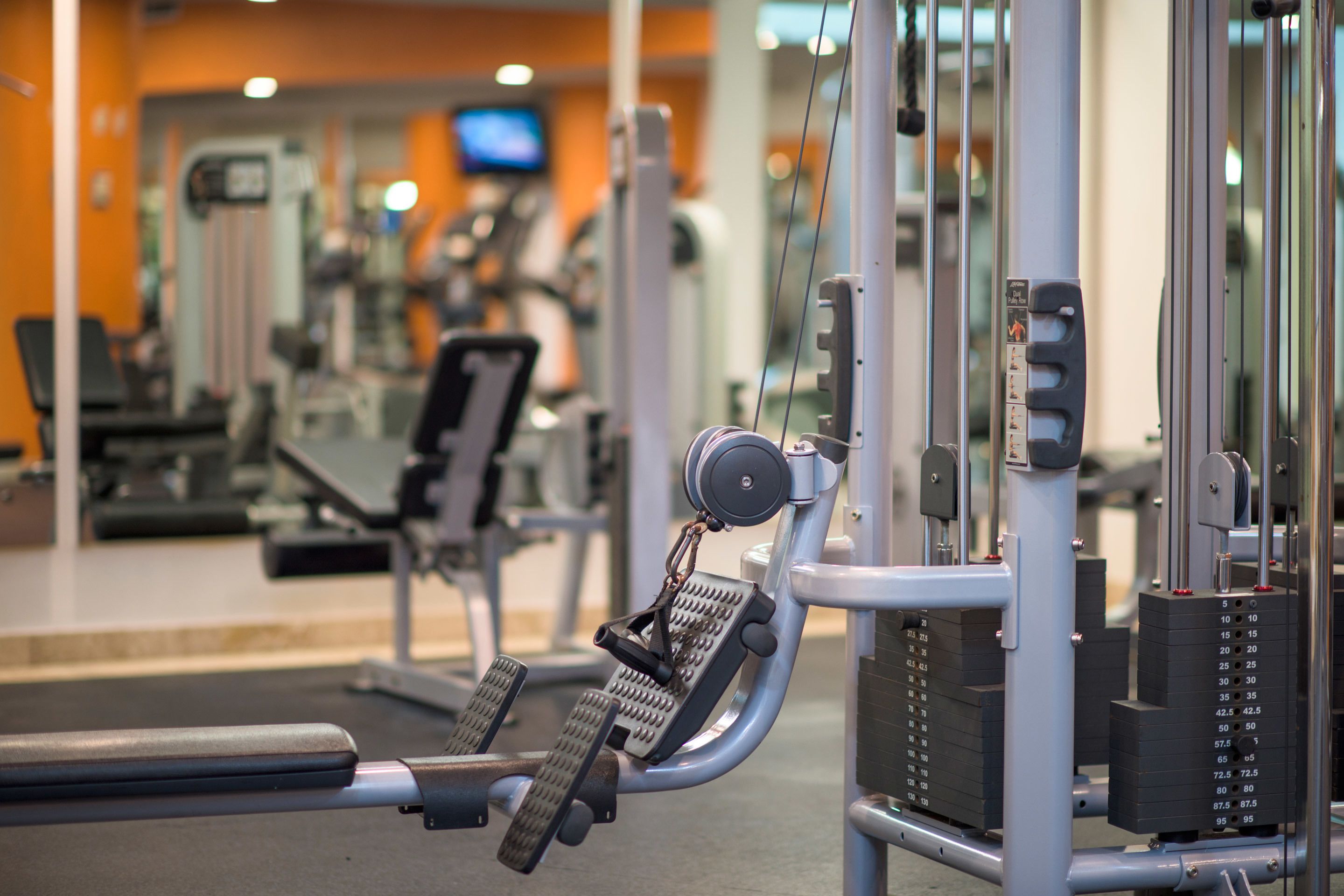 A gym with exercise equipment, including a leg press machine and weight stacks.