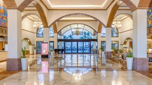 Eine großzügige Lobby mit hohen Decken, Rundbogenfenstern und Kronleuchtern.