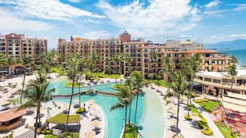 Relax by the pool surrounded by palm trees and lounge areas, with stunning ocean views from the balconies of our multi-story buildings.