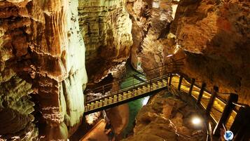 A cave with a wooden walkway and a metal railing.