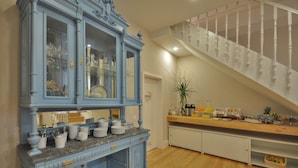 A kitchen with a blue cabinet, wooden countertop, and a staircase with white balusters. - Porto Charming Hotel (Porto)