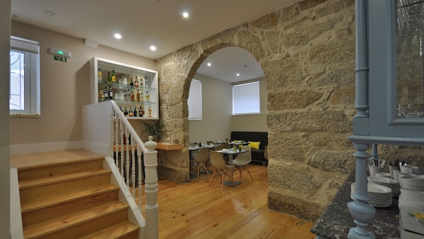 A staircase leading to a dining area with stone walls and wooden floors. - Porto Charming Hotel (Porto)