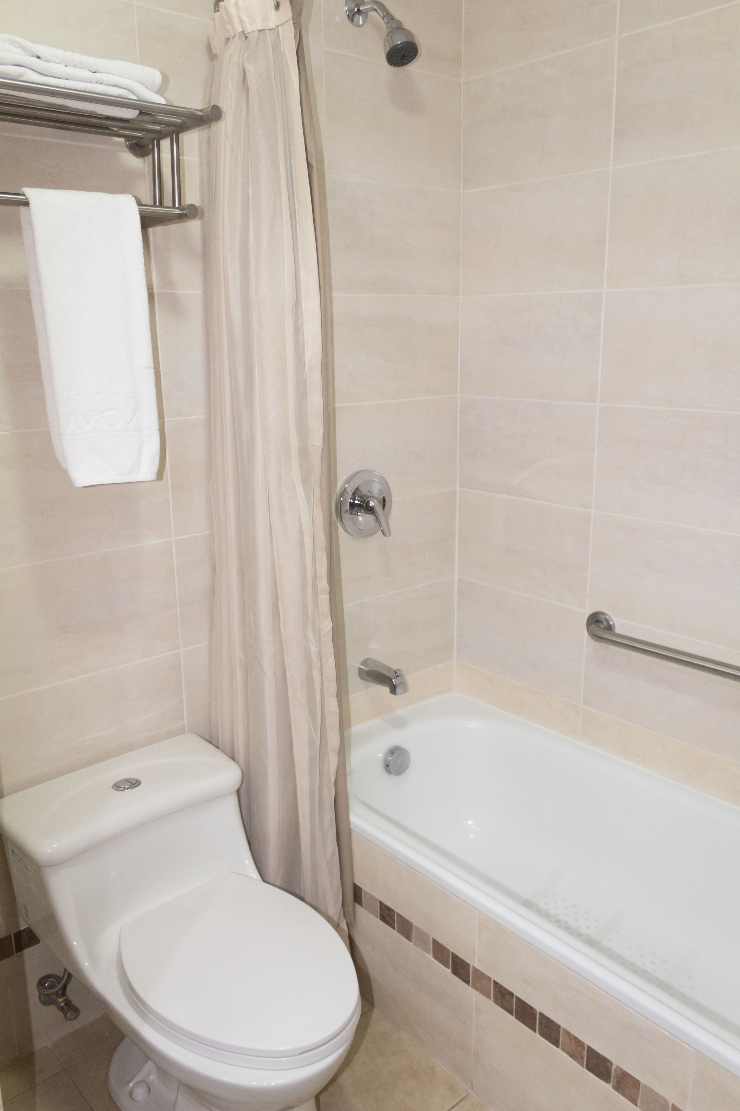 A bathroom with a toilet, a bathtub, and a shower curtain.