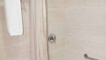 A bathroom with a toilet, a bathtub, and a shower curtain.
