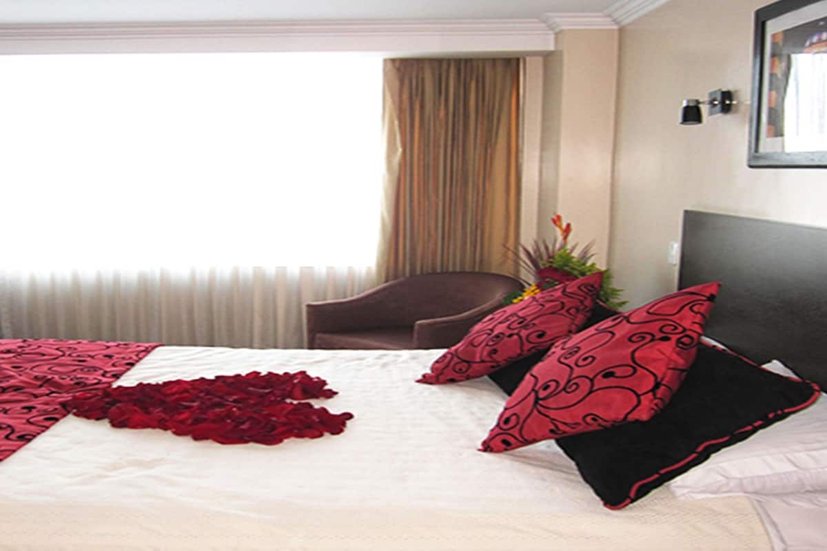 Ein Hotelzimmer mit Bett, Stuhl und einem Vorhangfenster.