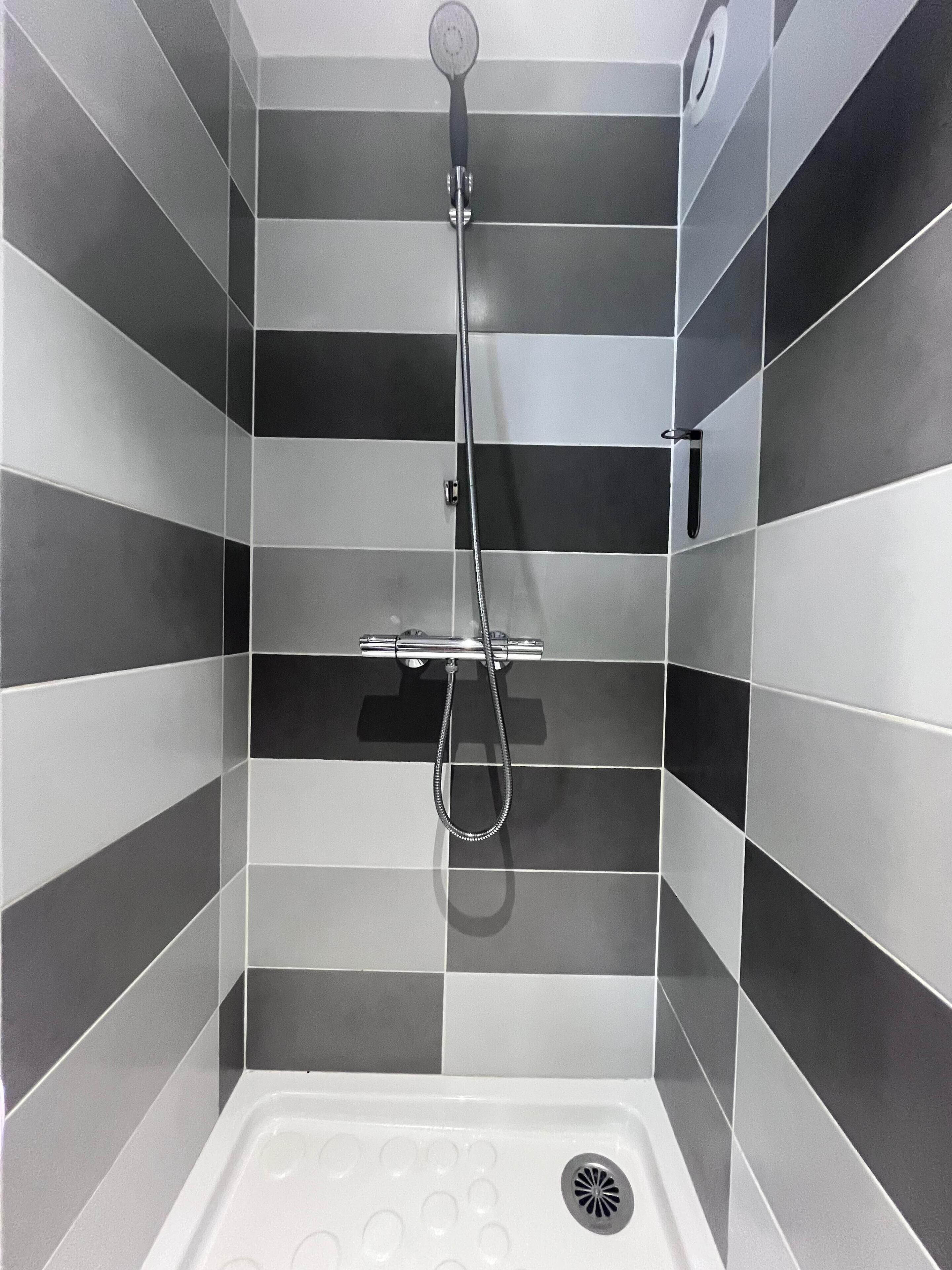 Een douche met een handdouche en een doucheslang.
