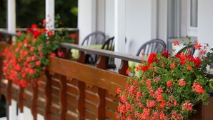 Barandal de madera con flores rojas.