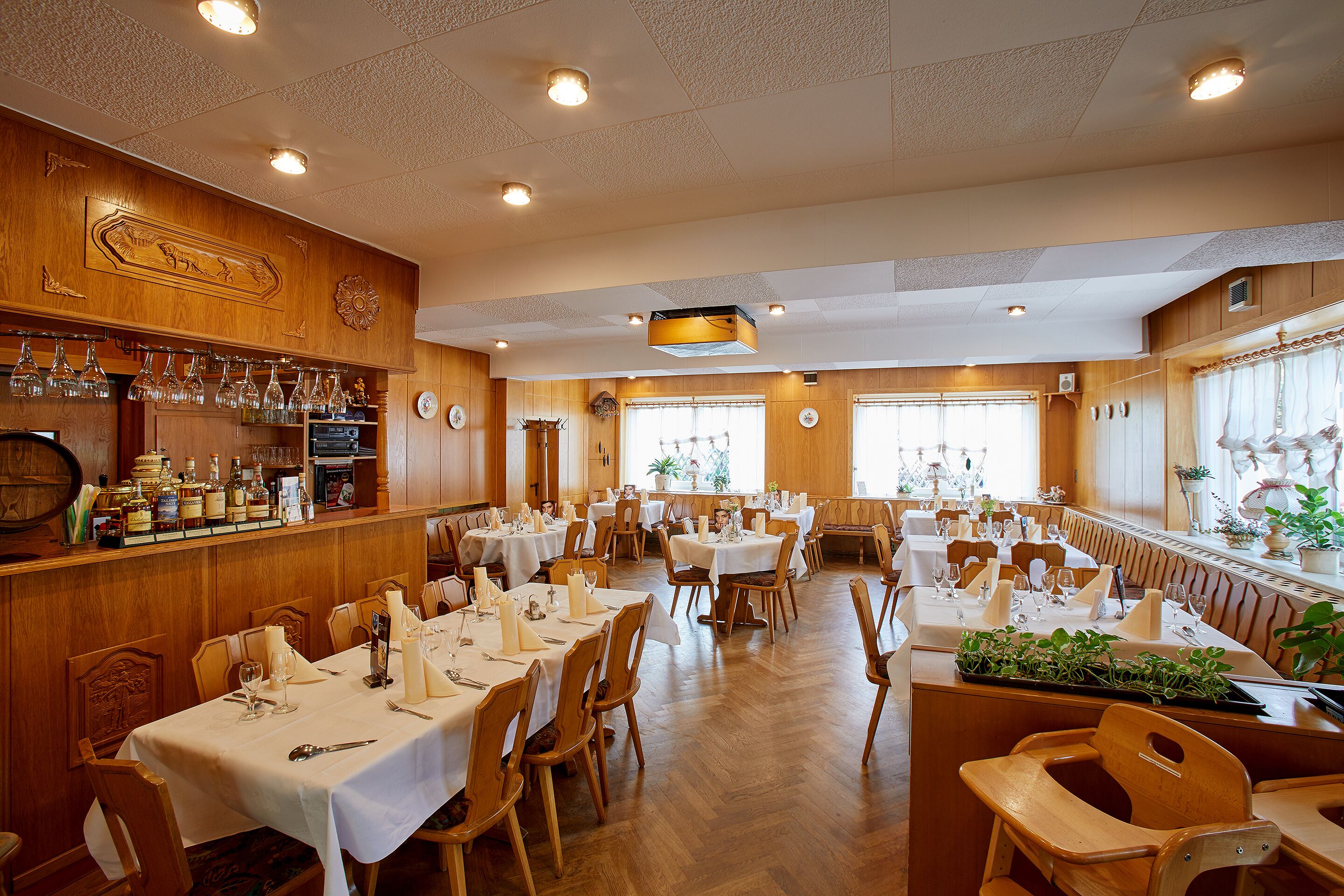 Un restaurante con varias mesas, decoración de madera y una zona de bar.