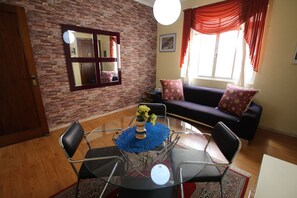 A living room with a glass table, chairs, a sofa, and a brick wall. - Go house Arouche SP 804 (São Paulo)