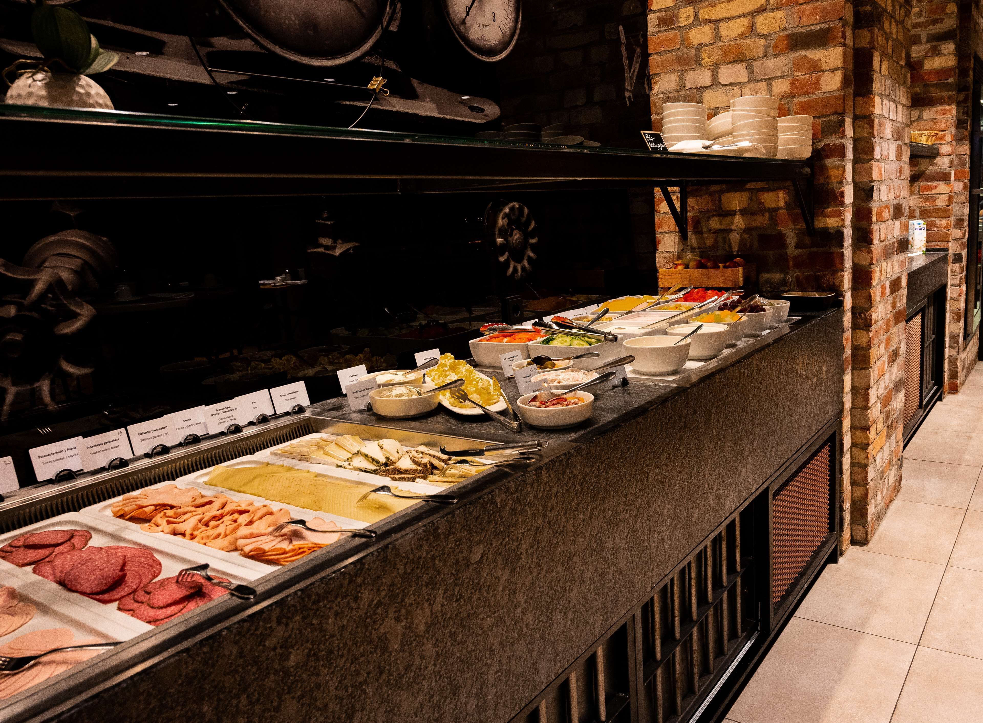 A buffet with various food options, including meats, salads, and desserts.