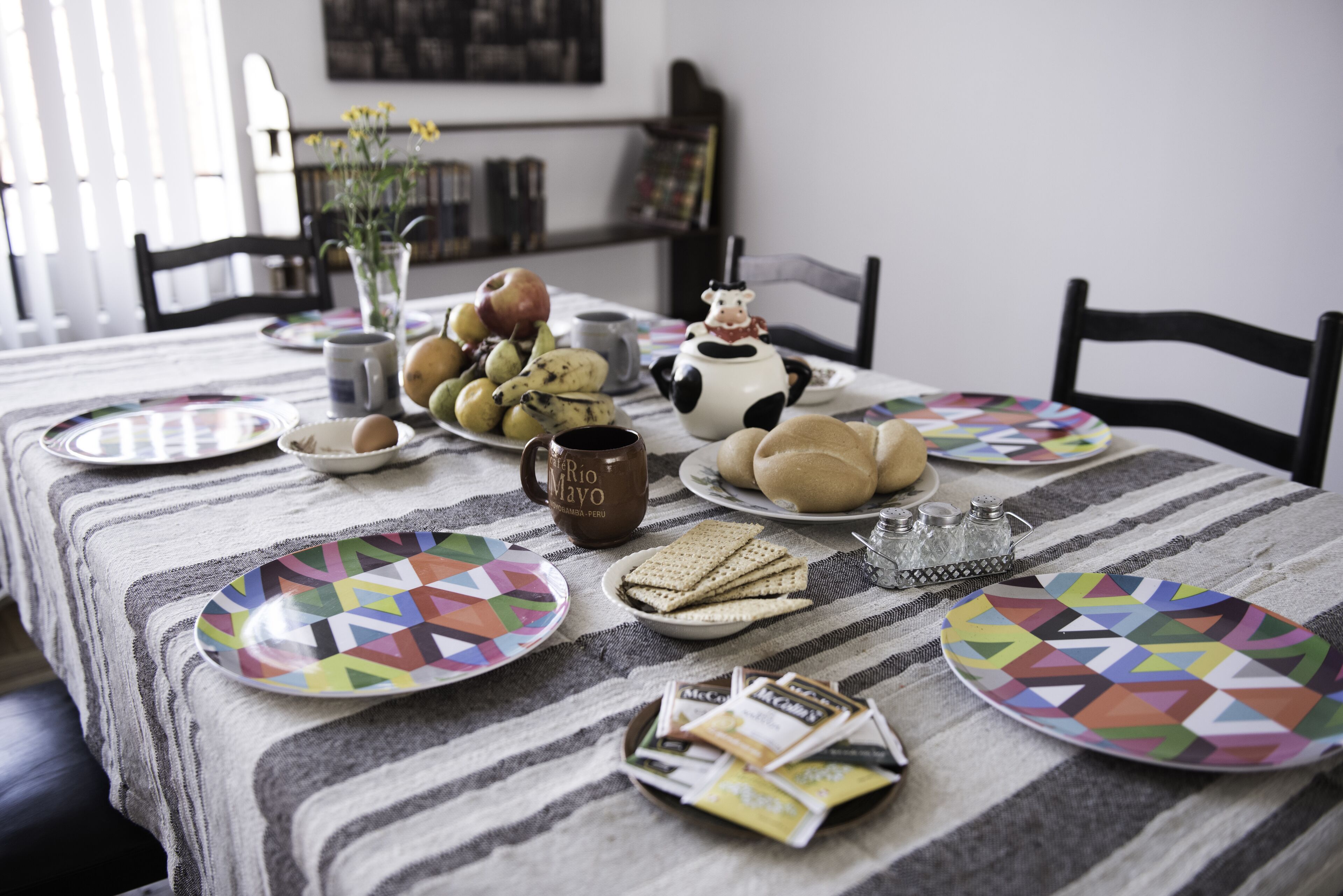 A dining table with plates, a mug, and various food items.