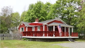 A red house with a porch and a flag.