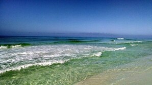Una playa con agua cristalina y olas.