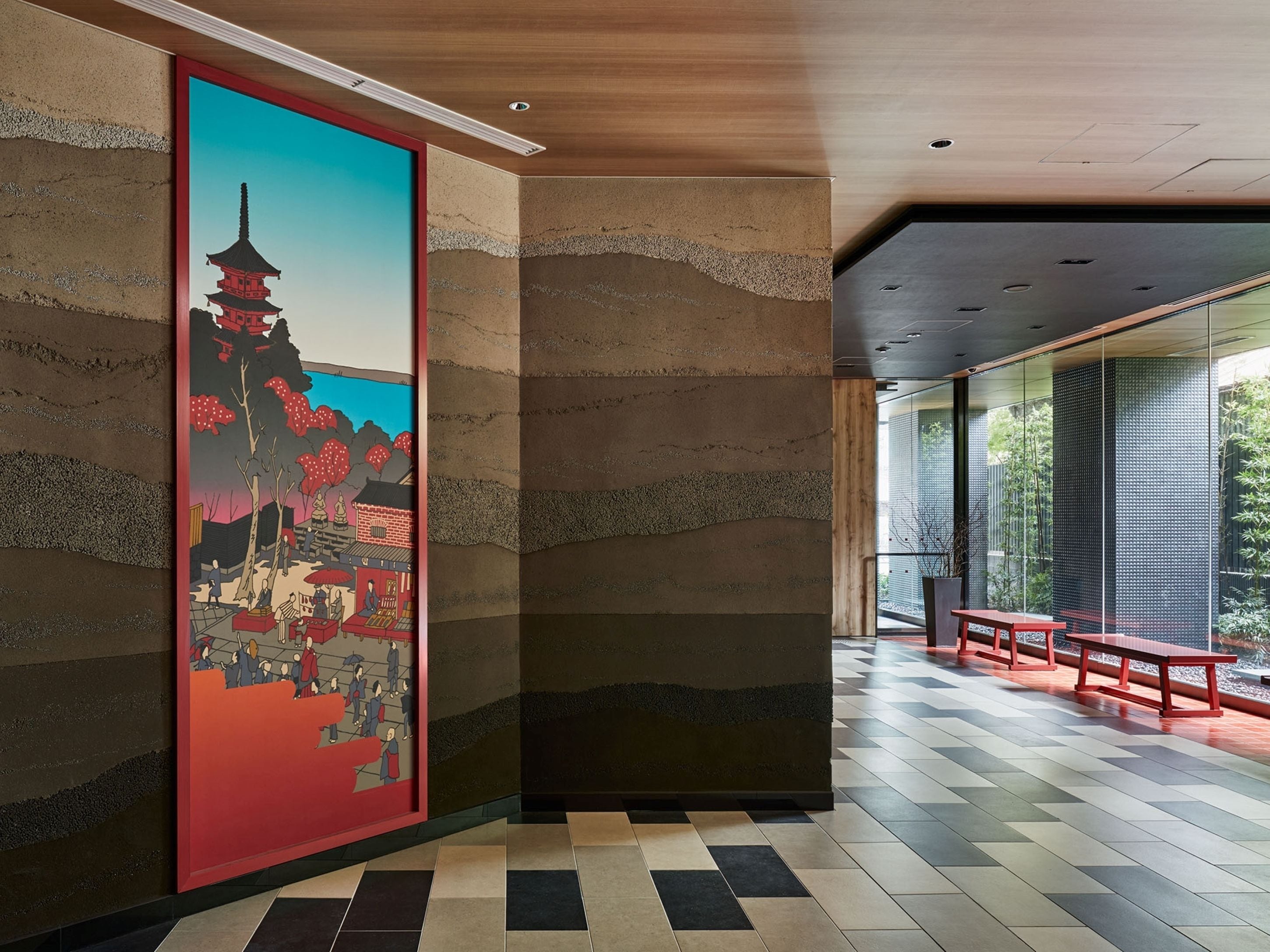 A hallway with a traditional Japanese mural, a tiled floor, and a seating area with benches.