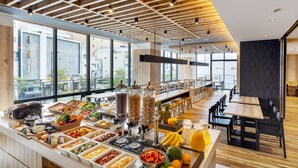 A modern dining area with a buffet setup, large windows, and a wooden ceiling. - the b asakusa (Tokyo)