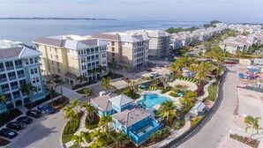 Un hôtel situé sur la côte, composé de plusieurs bâtiments, doté d’une piscine et bordé de palmiers.