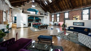 A spacious loft with high ceilings, exposed beams, and a mix of modern and industrial decor. - Luxurious, Converted Church Ideal for Large Groups near RiNo District, Sleeps 22 (Denver)