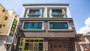 A multi-story building with a large entrance, a visible garage door, and a sign with Chinese characters. - Guanshan Fukuda Homestay (Guanshan)