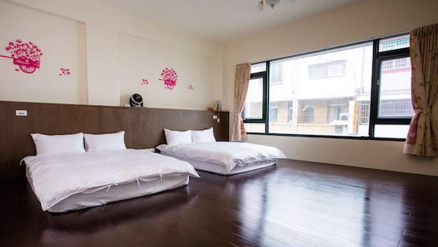 A hotel room with two beds, a large window with curtains, and decorative wall stickers. - Guanshan Fukuda Homestay (Guanshan)