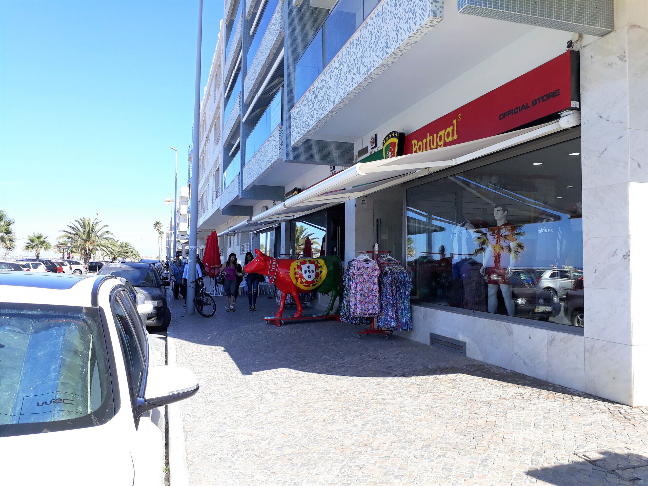 A storefront with a sign reading "Official Store" and a large bull statue outside.