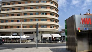 A multi-story building with a curved facade, outdoor seating area, and a sign for 'El Perchel'. - Orient Express Apartment - In The Station (Málaga)