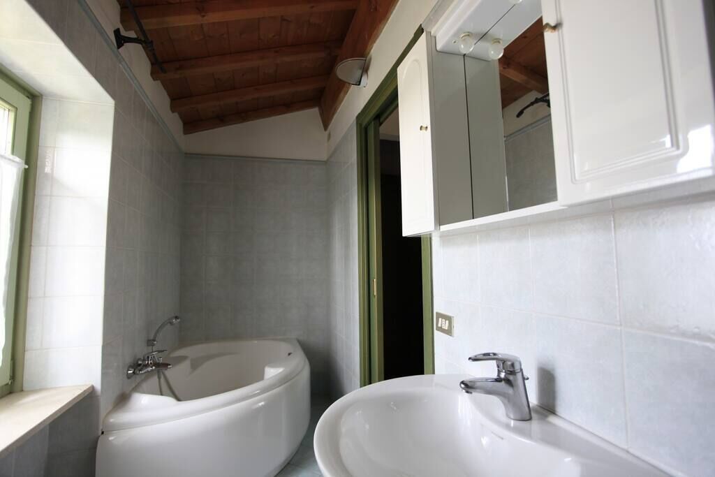 A bathroom with a bathtub, a sink, and a mirror.