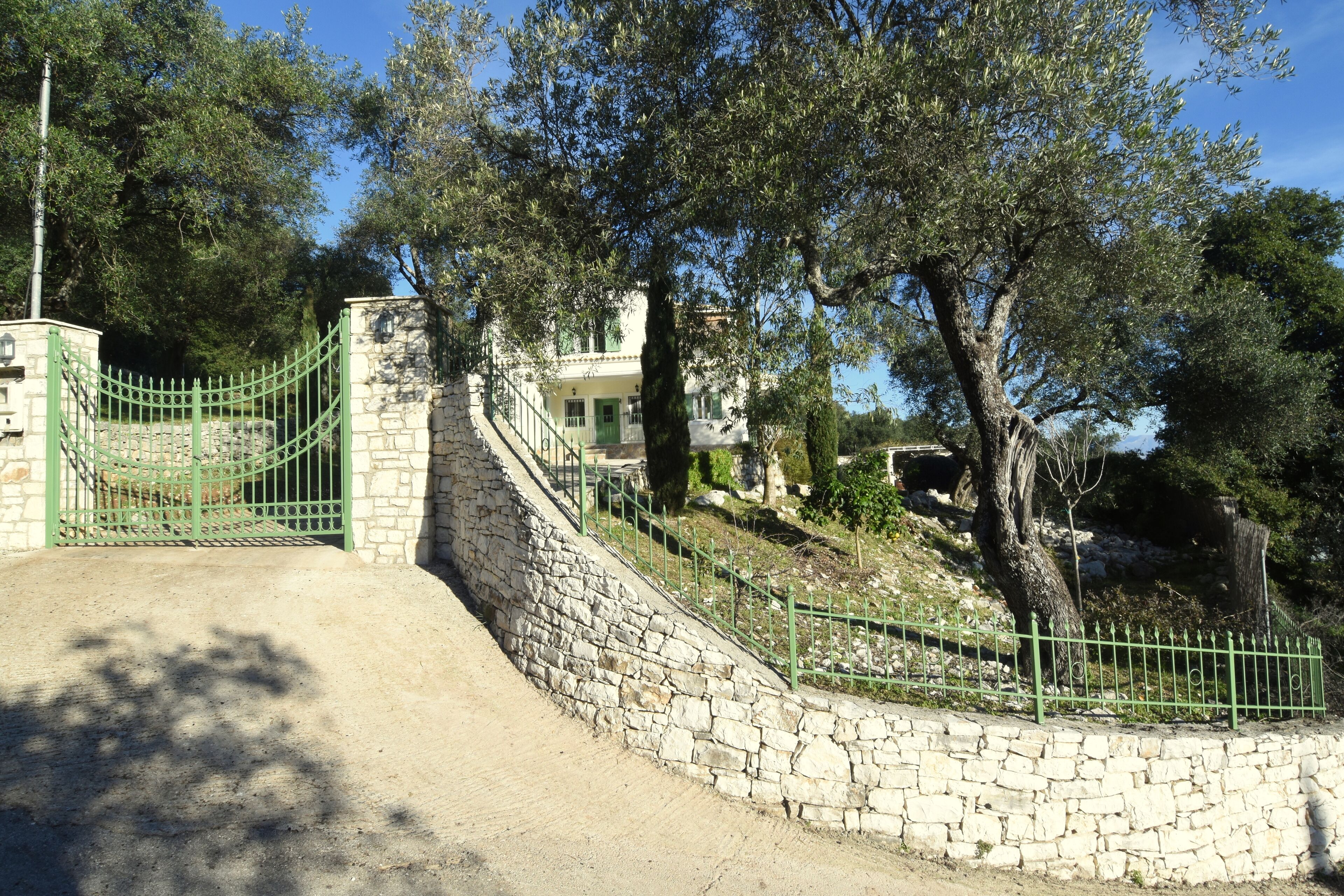 A stone staircase leading to a building with a green gate.