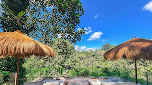 A wooden deck with two thatched umbrellas and two lounge chairs with cushions. - Villa Kalisha - Romantic Honeymoon or Family Getaway in Ubud (Tegallalang)