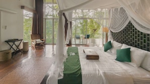 A room with a bed, a chair, a table, and a view of greenery outside. - Villa Kalisha - Romantic Honeymoon or Family Getaway in Ubud (Tegallalang)