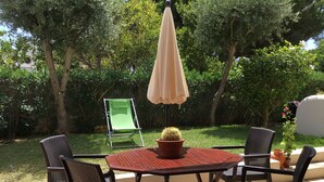 An outdoor patio with a round table, four chairs, a single umbrella, and a cactus centerpiece. - Apartment in resort 3* at 1mn to the beach - Algarve (Porches)