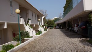 A cobblestone street flanked by buildings with balconies and outdoor lighting. - Apartment in resort 3* at 1mn to the beach - Algarve (Porches)