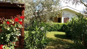 A garden with a wooden structure and red flowers, leading to a building labeled "La Roselle Residence". - Garda Residences   Le Rasole Economy (Garda)