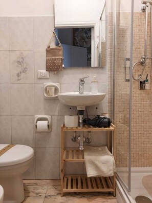 Une salle de bain avec des toilettes, un lavabo et une douche.
