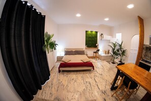 Une chambre à coucher avec un lit, un bureau et une table à manger.