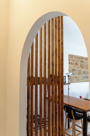 Un espace repas agrémenté d’une cloison en bois, d’un mur en pierre et d’une table avec des chaises.