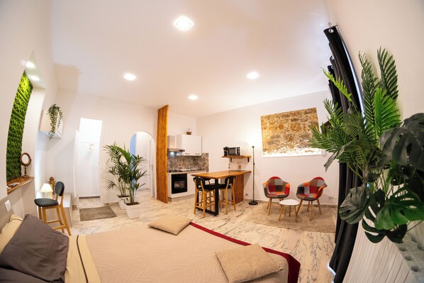 Un espace de vie moderne et ouvert, comprenant une cuisine, un coin repas et un coin salon confortable.