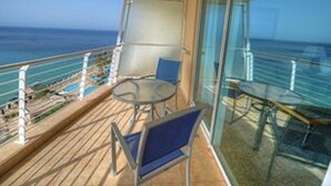 A balcony with a glass railing, a table, and two chairs. - Apartment Two Weeks Right of Use at Radisson Blu Resort & Spa, Golden Sands (L/o Mellieha)