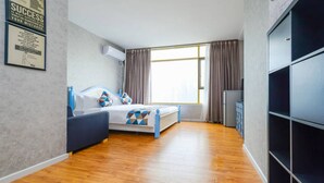 Ein modernes Schlafzimmer mit Bett, Kleiderschrank und Fenster.